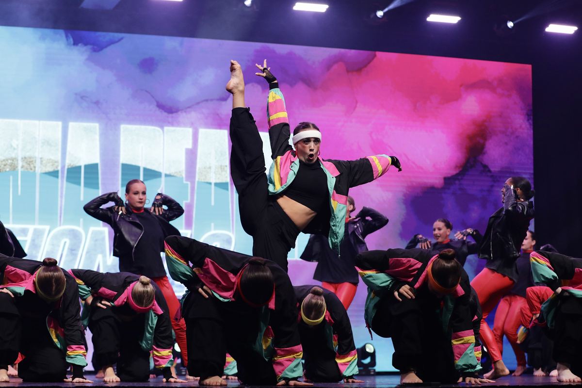 A hip-hop group in bright jackets mid-routine